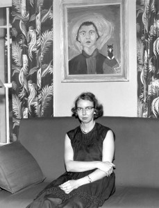 Flannery O'Connor seated beneath her iconic self-portrait